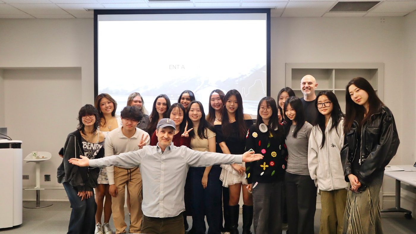 A class photo in front of a projector screen